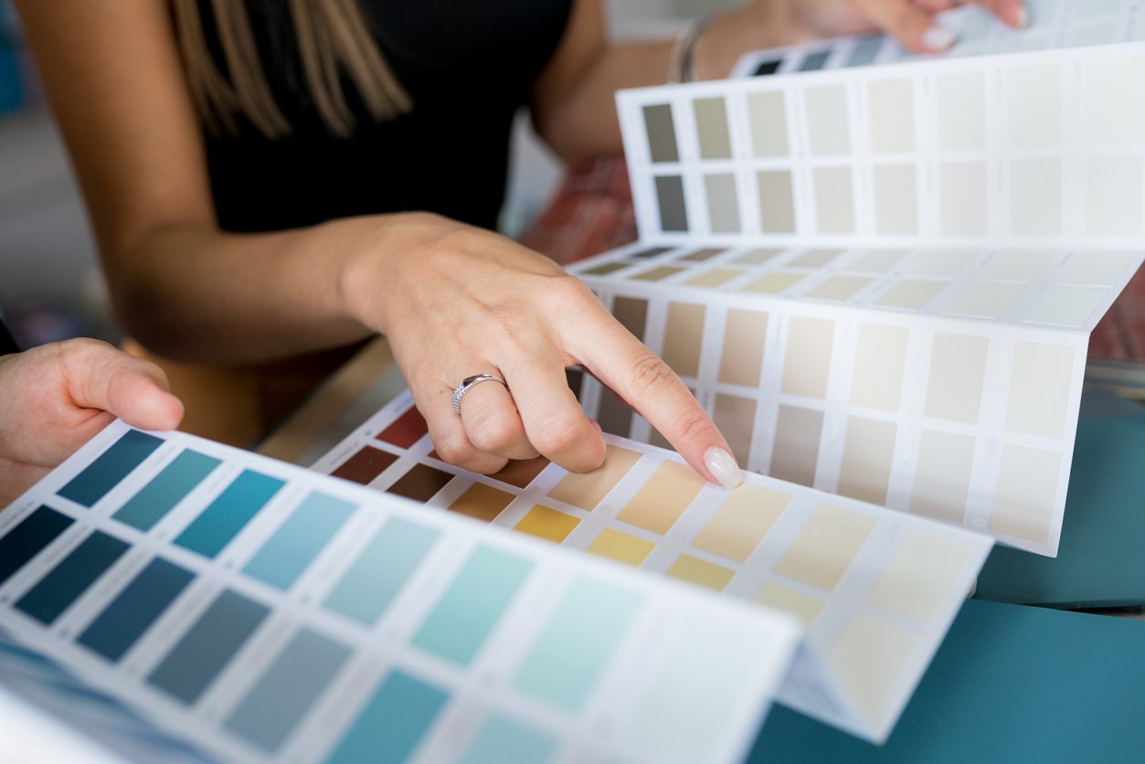 choosing samples of wall paint Interior designer consulting a client looking at a color swatch House renovation concept custom paint colors