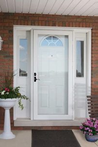 A white door stands next to a colorful flower pot, adding charm to the entrance.