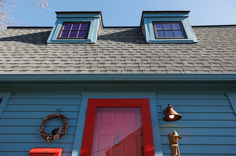 beautiful blue siding and a red door